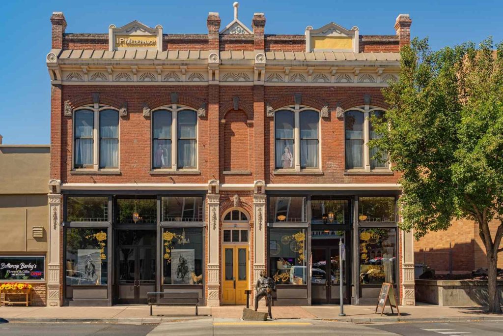 Historic 1896 brick building with arched windows and storefronts in downtown Pendleton, Oregon